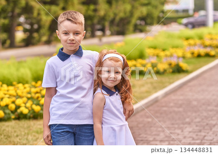 Caucasian young boy and girl smiling outdoors in park on a sunny day Caucasian young boy and girl smiling outdoors in park on a sunny day 134448831