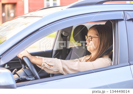 Young caucasian woman driving car with focused expression in suburban 134449014