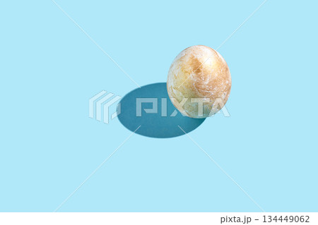 Single egg on light blue background with shadow from sunlight Single egg on light blue background with shadow from sunlight 134449062
