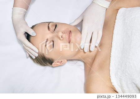 Female caucasian adult receiving relaxing facial massage with spa gloves Female caucasian adult receiving relaxing facial massage with spa gloves 134449093