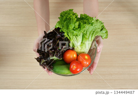 Healthy Eating. Woman holding a bowl of fresh vegetables with a smile. Healthy Eating. Woman holding a bowl of fresh vegetables with a smile. 134449487