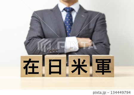 「在日米軍」と書かれたブロックと腕組みをするビジネスマン 「在日米軍」と書かれたブロックと腕組みをするビジネスマン 134449794