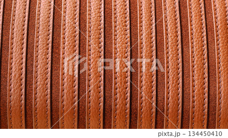 Striped brown leather texture with visible grain and stitching in natural warm tones. Natural background ideal for fashion, upholstery, bags, accessories, copy space Striped brown leather texture with visible grain and stitching in natural warm tones. Natural background ideal for fashion, upholstery, bags, accessories, copy space 134450410