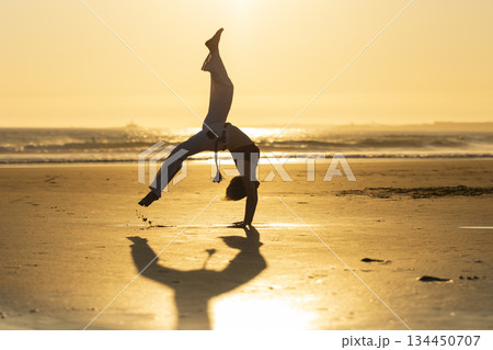 Capoeira artist performing on beach during sunset Capoeira artist performing on beach during sunset 134450707
