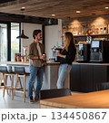 モダンなカフェでコーヒーを飲みながら会話する男女 134450867