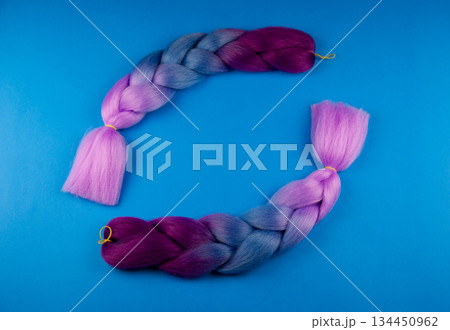 Colored braids on a blue background. 134450962