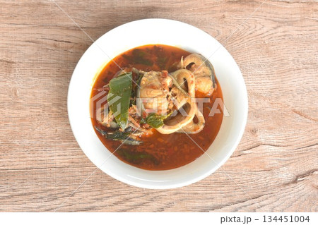 spicy chili boiled catfish with eggplant and basil in curry soup on bowl 134451004