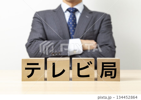 「テレビ局」と書かれたブロックと腕組みをするビジネスマン 「テレビ局」と書かれたブロックと腕組みをするビジネスマン 134452864