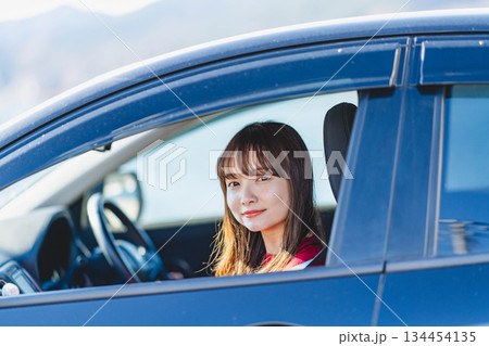 車の助手席に乗り楽しそうにするロングヘアの若い女性 134454135
