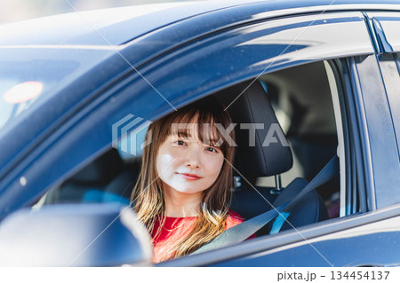 車の助手席に乗り楽しそうにするロングヘアの若い女性 134454137