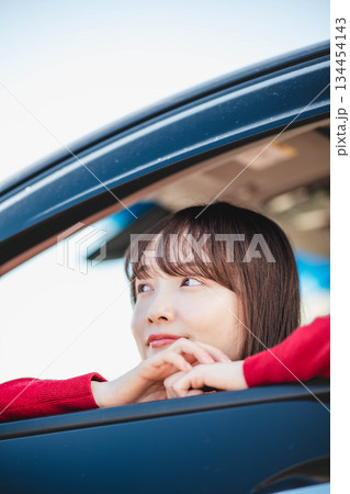 車の助手席に乗り楽しそうにするロングヘアの若い女性 134454143