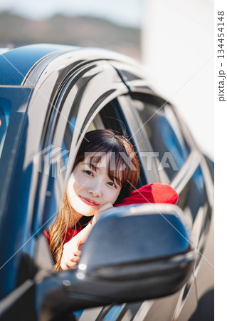 車の助手席に乗り楽しそうにするロングヘアの若い女性 134454148