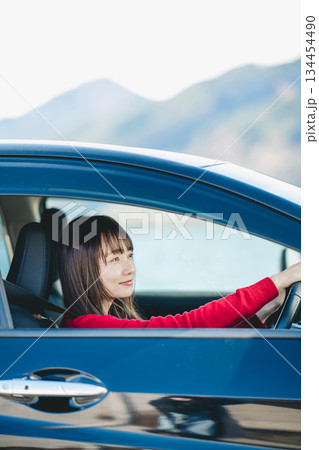 車を運転する若い女性 134454490
