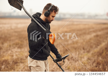 Archeology conception. Man is with metal detector in the field Archeology conception. Man is with metal detector in the field 134454657