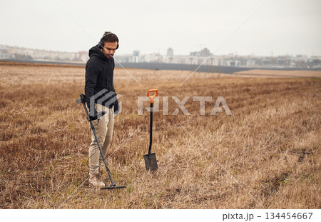 Archeology conception. Man is with metal detector in the field Archeology conception. Man is with metal detector in the field 134454667