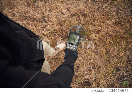 Information on the display. Man is with metal detector in the field Information on the display. Man is with metal detector in the field 134454673