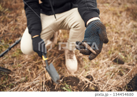 Sitting, holding old bullet. Man is with metal detector in the field Sitting, holding old bullet. Man is with metal detector in the field 134454680