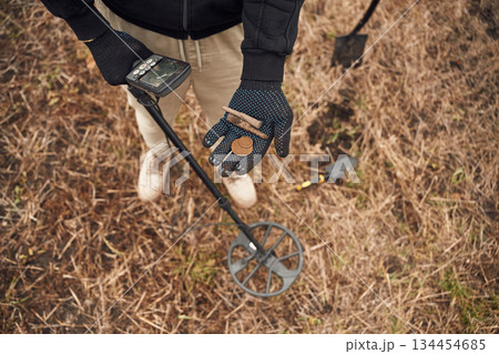 Old bullets and coin. Man is with metal detector in the field Old bullets and coin. Man is with metal detector in the field 134454685