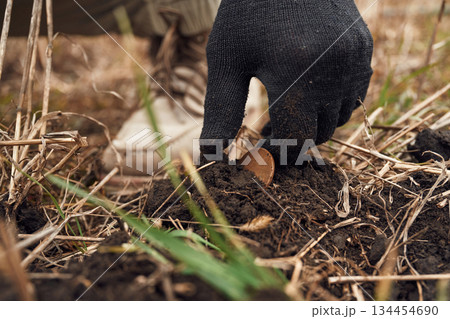 Close up view of man that found old coin on the field Close up view of man that found old coin on the field 134454690