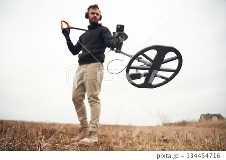 Man is with metal detector in the field Man is with metal detector in the field 134454716