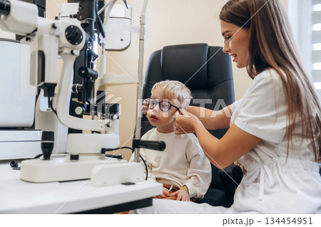 Trying new glasses. Little boy is having check up in the ophthalmologist cabinet Trying new glasses. Little boy is having check up in the ophthalmologist cabinet 134454951