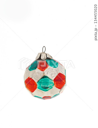Vintage glass Christmas ornament with colorful geometric painted facets isolated on white background. Vintage glass Christmas ornament with colorful geometric painted facets isolated on white background. 134455020