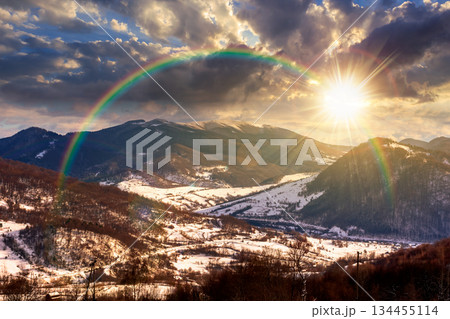 mountainous rural landscape in winter at sunset. snow covered fields on hills in evening light. village in the valley. landscape with clouds on sky. leadership corporate wallpaper under the rainbow mountainous rural landscape in winter at sunset. snow covered fields on hills in evening light. village in the valley. landscape with clouds on sky. leadership corporate wallpaper under the rainbow 134455114