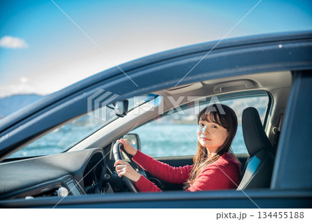 晴れた日に車を運転する若いロングヘアの女性 晴れた日に車を運転する若いロングヘアの女性 134455188