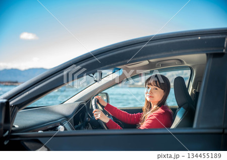 晴れた日に車を運転する若いロングヘアの女性 晴れた日に車を運転する若いロングヘアの女性 134455189