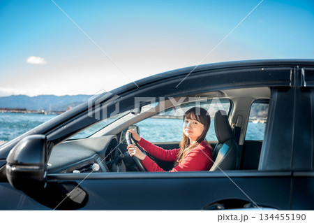 晴れた日に車を運転する若いロングヘアの女性 134455190