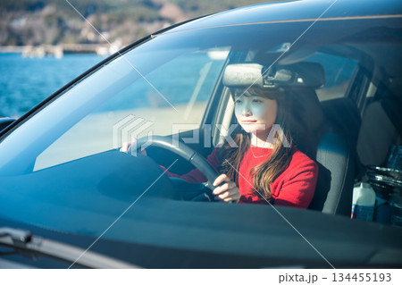 晴れた日に車を運転する若いロングヘアの女性 134455193