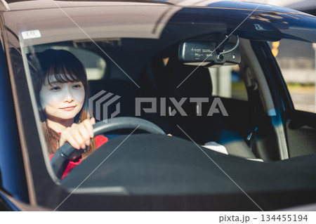 晴れた日に車を運転する若いロングヘアの女性 134455194