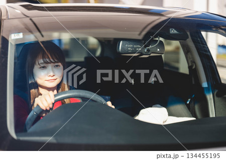 晴れた日に車を運転する若いロングヘアの女性 134455195