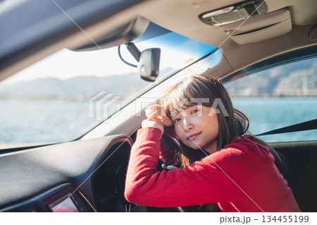 晴れた日に車を運転する若いロングヘアの女性 晴れた日に車を運転する若いロングヘアの女性 134455199
