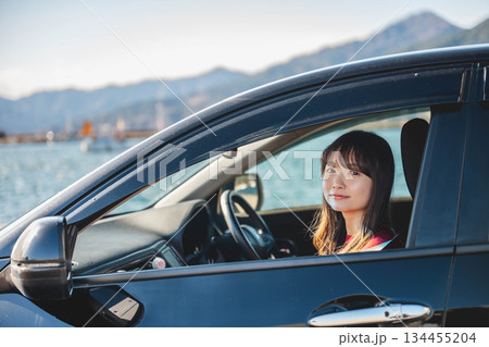 晴れた日に車を運転する若いロングヘアの女性 134455204