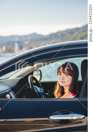 晴れた日に車を運転する若いロングヘアの女性 晴れた日に車を運転する若いロングヘアの女性 134455205