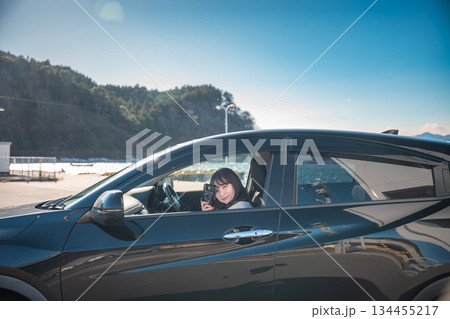 晴れた日に車を運転する若いロングヘアの女性 晴れた日に車を運転する若いロングヘアの女性 134455217