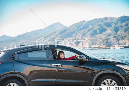 晴れた日に車を運転する若いロングヘアの女性 晴れた日に車を運転する若いロングヘアの女性 134455219