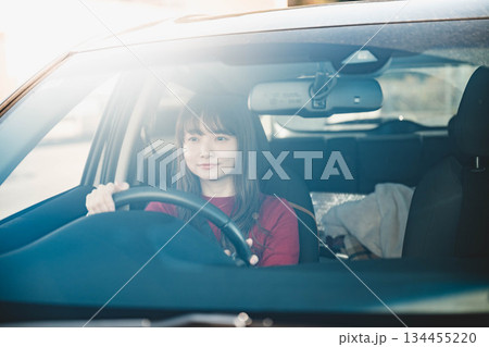 晴れた日に車を運転する若いロングヘアの女性 134455220