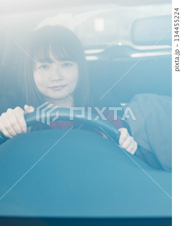 晴れた日に車を運転する若いロングヘアの女性 晴れた日に車を運転する若いロングヘアの女性 134455224