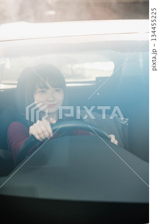 晴れた日に車を運転する若いロングヘアの女性 晴れた日に車を運転する若いロングヘアの女性 134455225