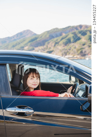 晴れた日に車を運転する若いロングヘアの女性 晴れた日に車を運転する若いロングヘアの女性 134455227