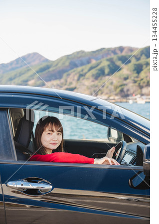 晴れた日に車を運転する若いロングヘアの女性 晴れた日に車を運転する若いロングヘアの女性 134455228