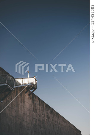 階段に座って空を見上げる若い女性 134455305