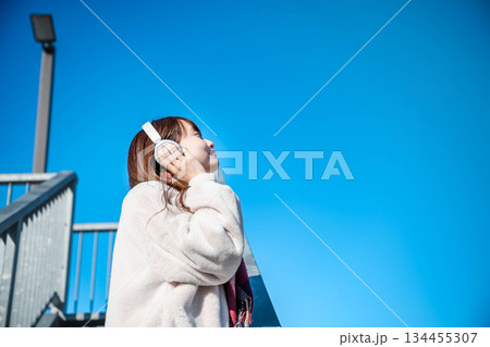 階段に座って空を見上げる若い女性 134455307