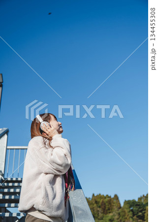 階段に座って空を見上げる若い女性 134455308