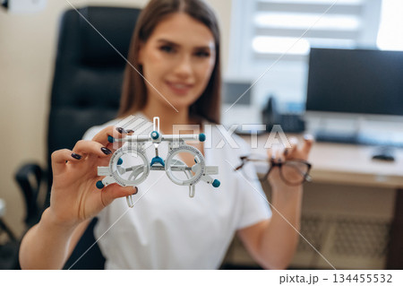 Gorgeous young female ophthalmologist is in the cabinet Gorgeous young female ophthalmologist is in the cabinet 134455532