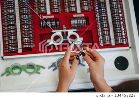 Ophthalmologist is picking different lenses that are in the kit Ophthalmologist is picking different lenses that are in the kit 134455828