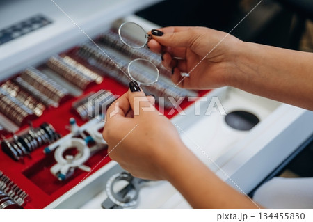 Ophthalmologist is picking different lenses that are in the kit Ophthalmologist is picking different lenses that are in the kit 134455830