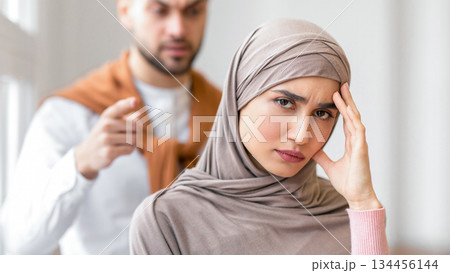 Unhappy Marriage. Angry Muslim Husband Shouting Threatening Wife Standing At Home. Domestic Violence And Victimization Issue. Relationship With Abuser. Selective Focus 134456144